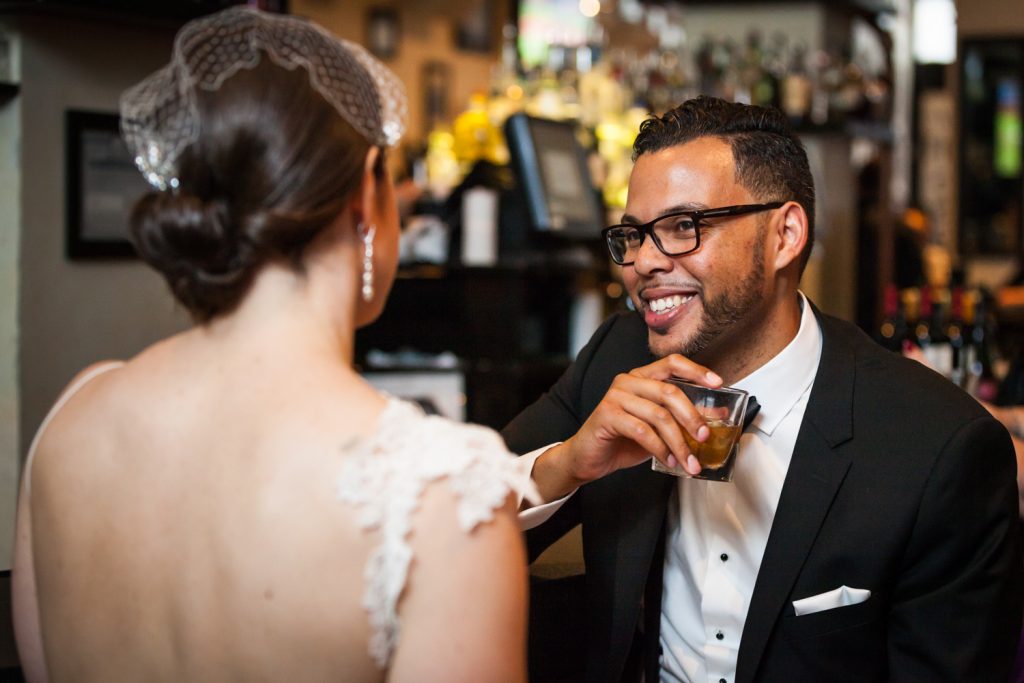 Groom laughing with drink in hand