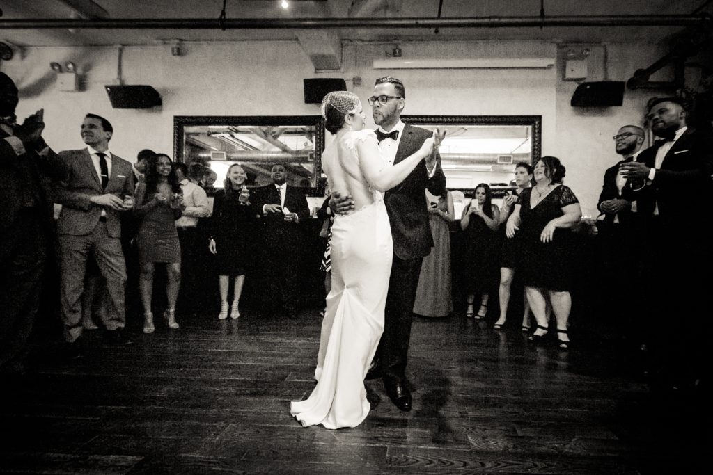 Black and white photo of bride and groom during first dance at wedding reception