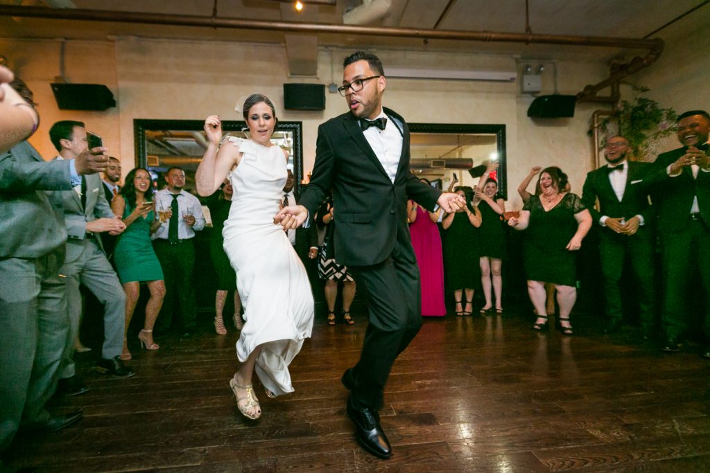 Bride and groom jumping in the air on the dance floor