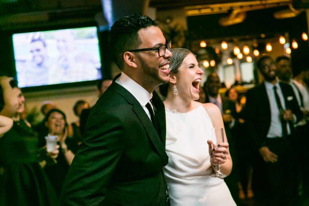 Bride and groom laughing at wedding reception