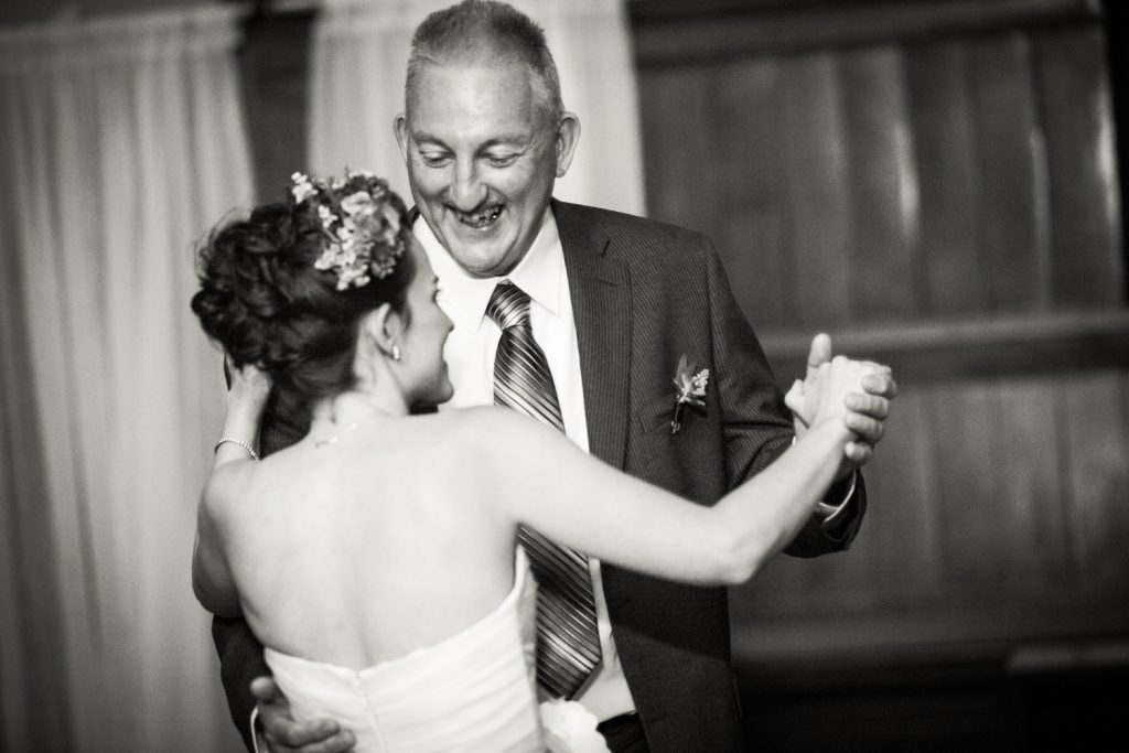 Black and white photo of bride dancing with her father