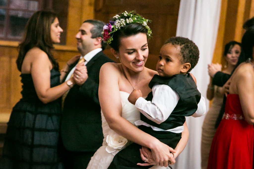 Bride dancing with little boy in her arms