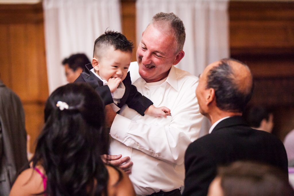 Father of bride dancing with little boy in his arms at a Snug Harbor wedding