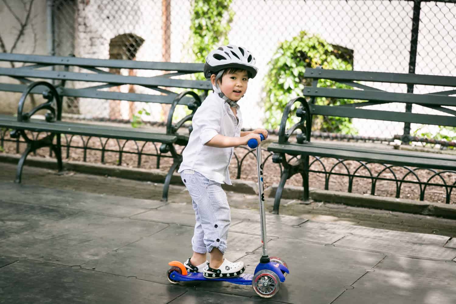 Little boy on scooter wearing bike helmet
