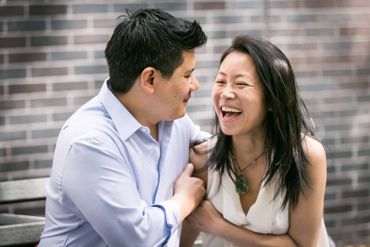Parents laughing in front of brick wall