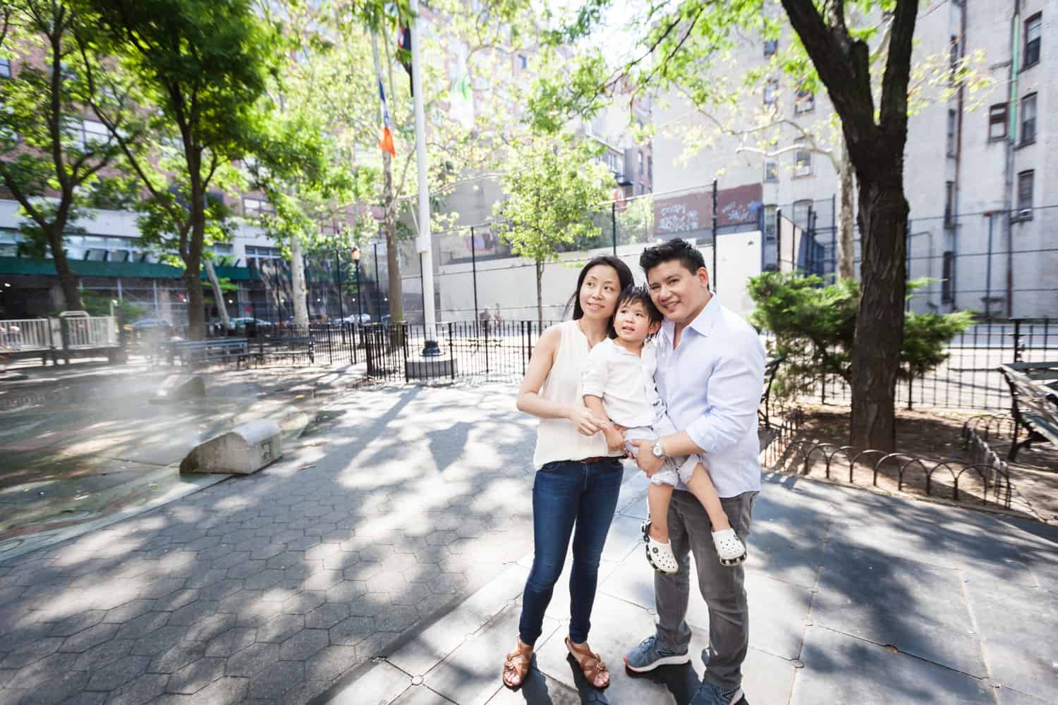 Chelsea family portrait of parents holding little boy in park
