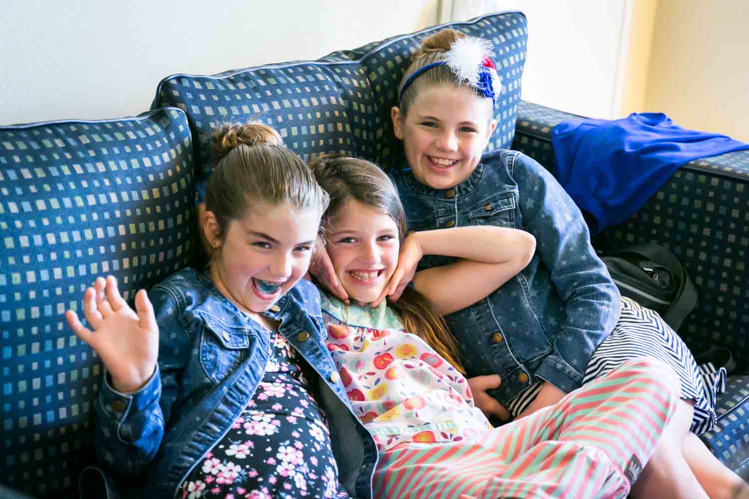 Three little girls playing around on a sofa