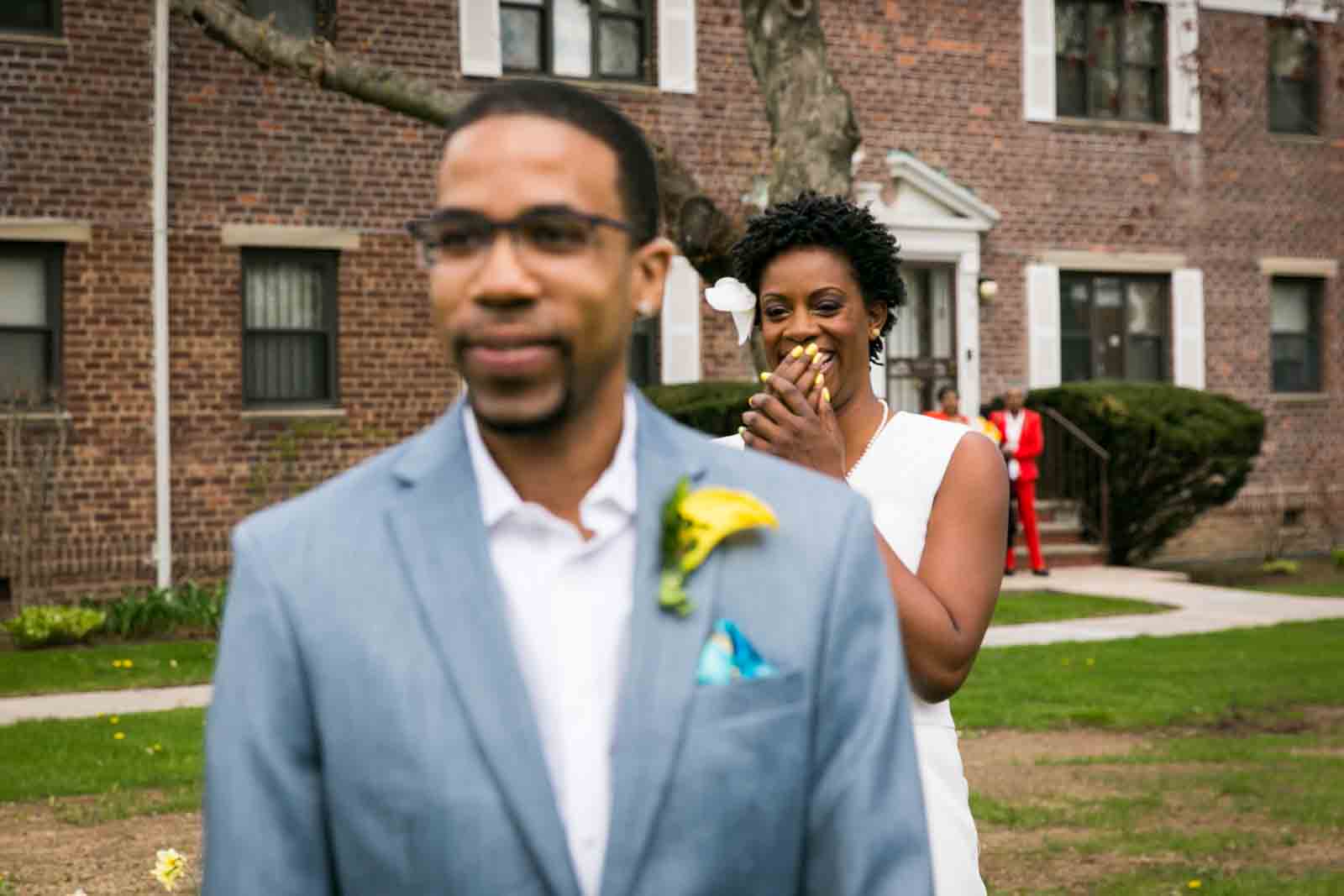 Bride laughing at groom during first look