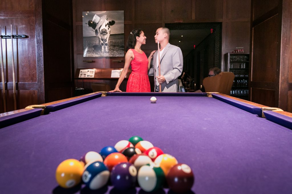 Couple looking at each other behind pool table