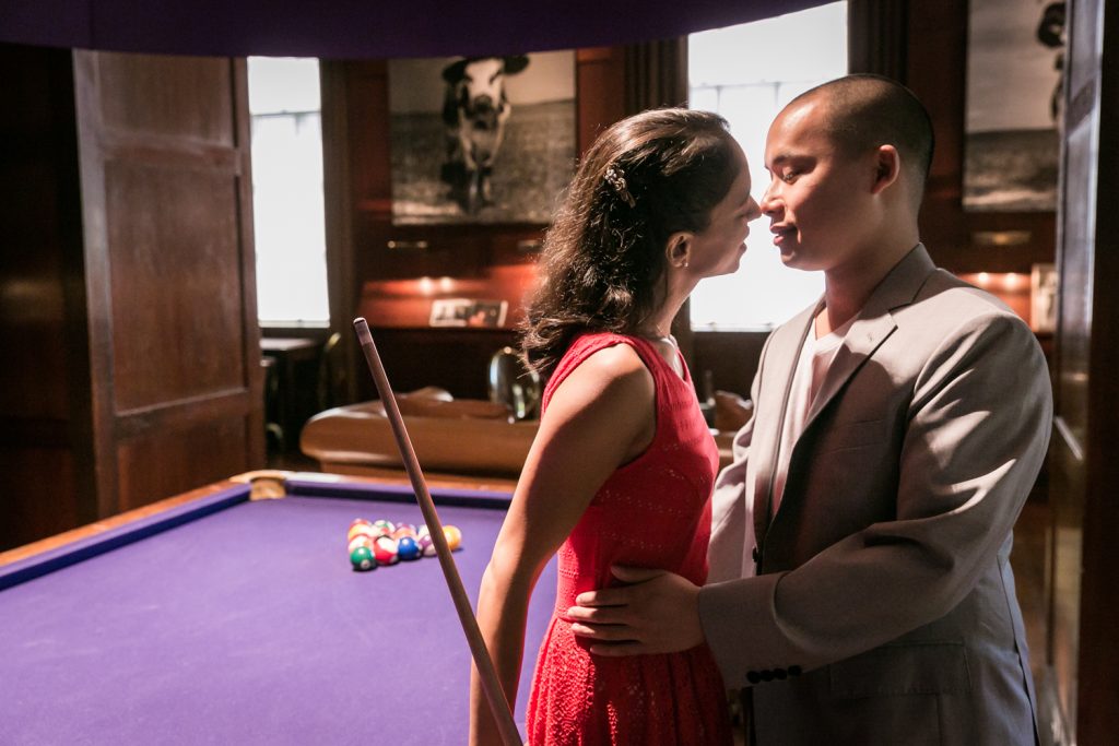 Couple about to kiss in front of pool table