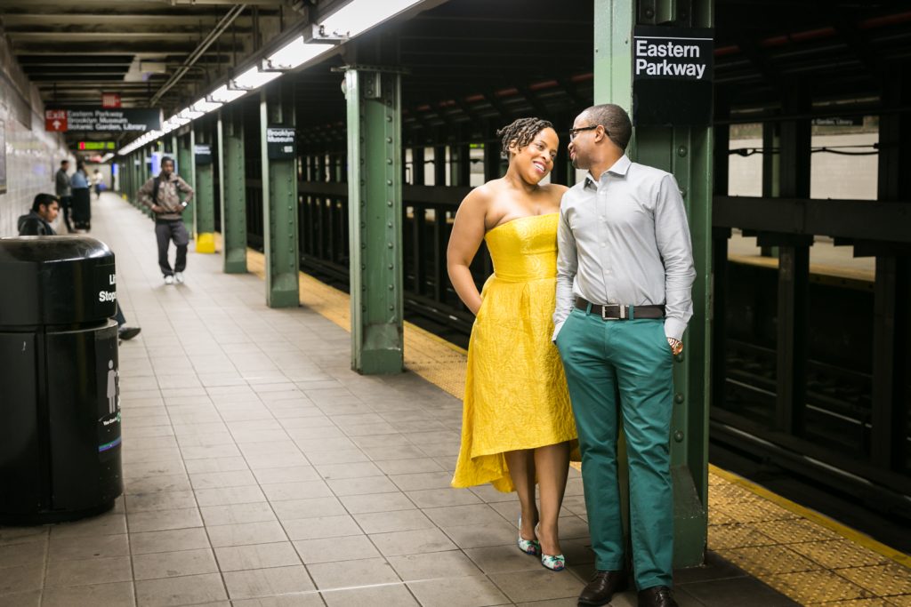 African American couple standing by column on Eastern Parkway subway platform