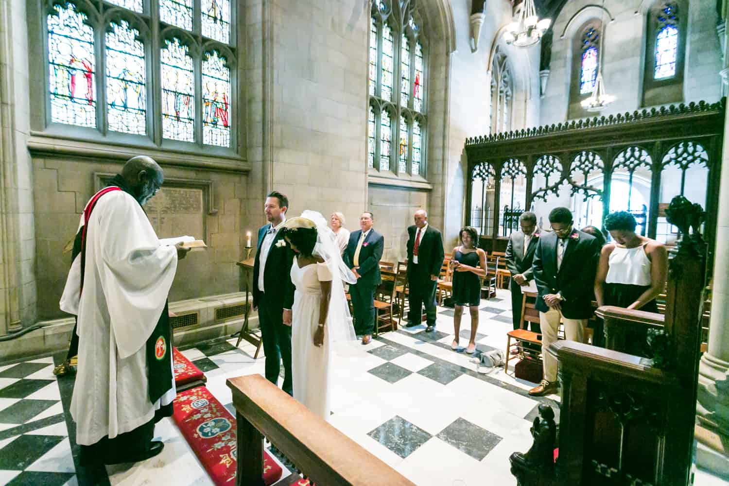 Bride and groom listening to priest during Trinity Church wedding ceremony