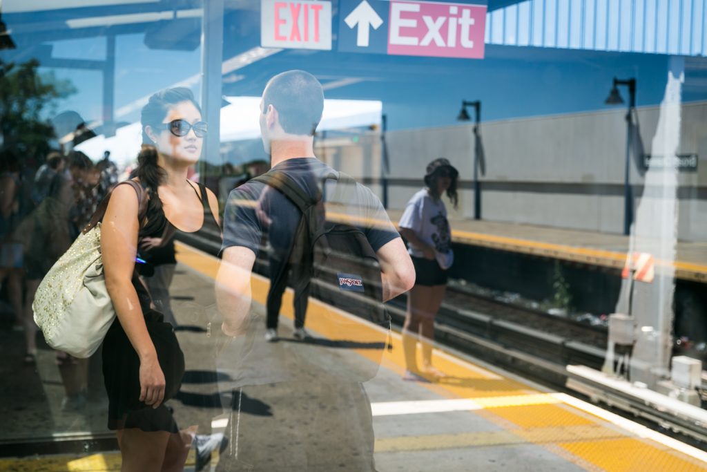 Couple in subway platform with reflection of woman waiting for train