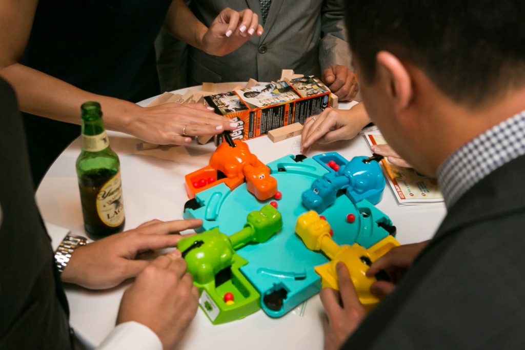Close up on wedding guest hands playing Hungry Hungry Hippos game at a reception