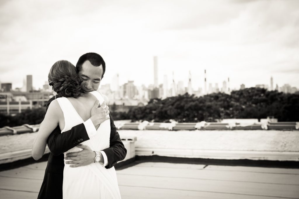 Black and white photo of bride and groom hugging after first look