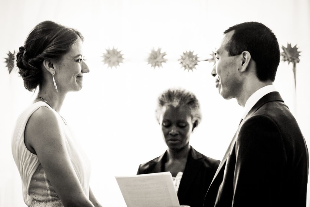 Black and white photo of bride and groom saying vows during Astoria wedding ceremony