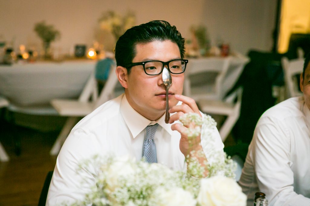 Wedding guest balancing spoon on his nose for an article on event entertainment ideas