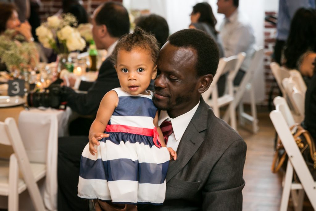 African American father holding little girl at Astoria wedding reception