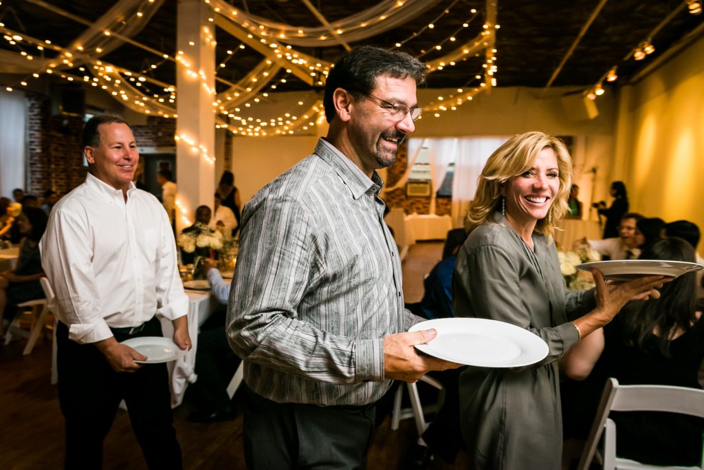 Guests in line at buffet holding plates at Astoria wedding reception