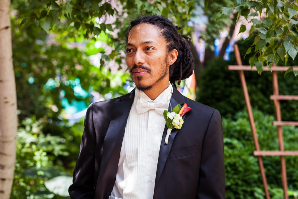 Portrait of groom with dreadlocks and wearing a tuxedo