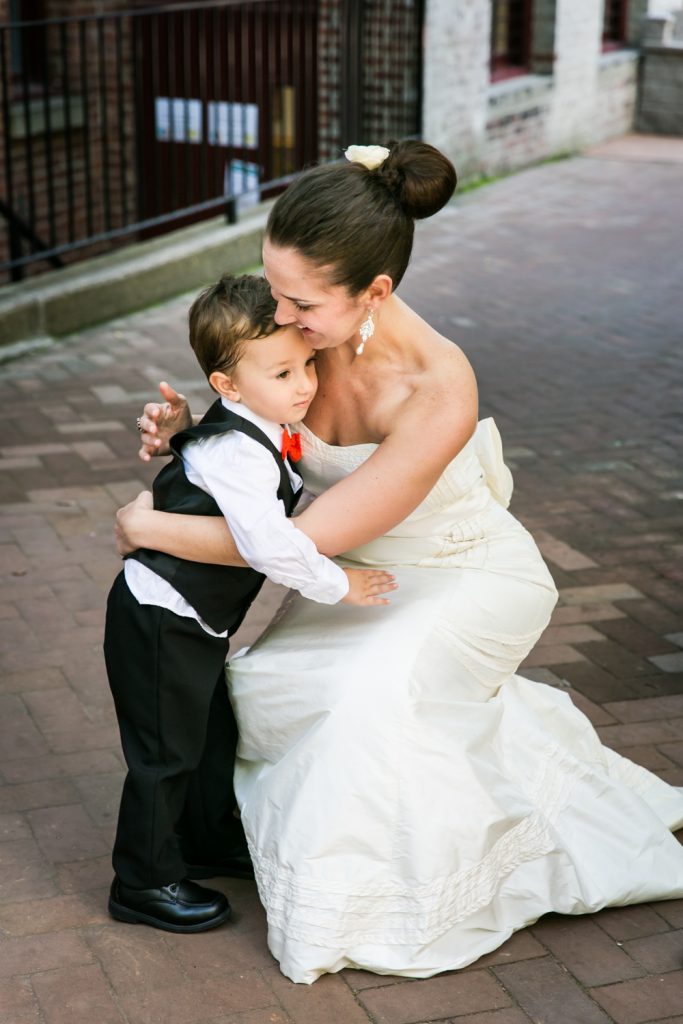 Bride bending down to hug a little boy at a DUMBO Loft wedding