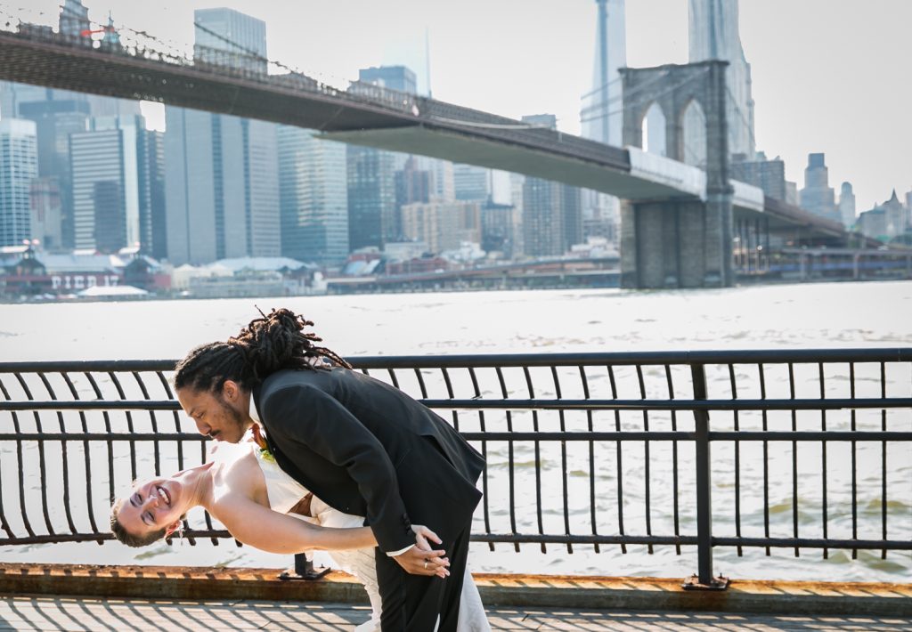 Groom dipping bride at Brooklyn Bridge Park for article on how to get the perfect first dance photos