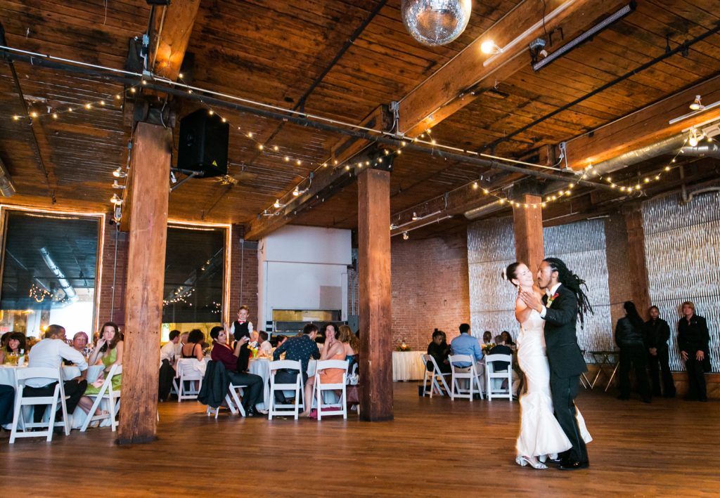 Bride and groom dancing alone on wide dance floor for article on how to get the perfect first dance photos