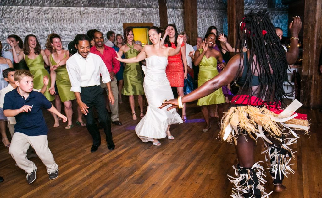 Bride and guests dancing with African dancer at a DUMBO Loft wedding