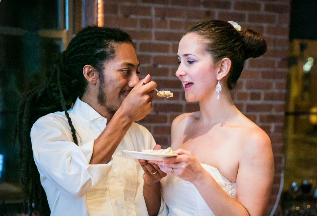 Groom feeding cake to bride at a DUMBO Loft wedding