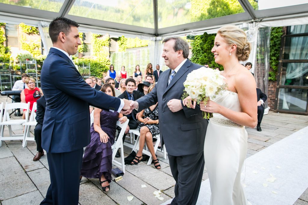 Groom shaking hand of bride's father during ceremony for an article on how to become a wedding officiant in NYC