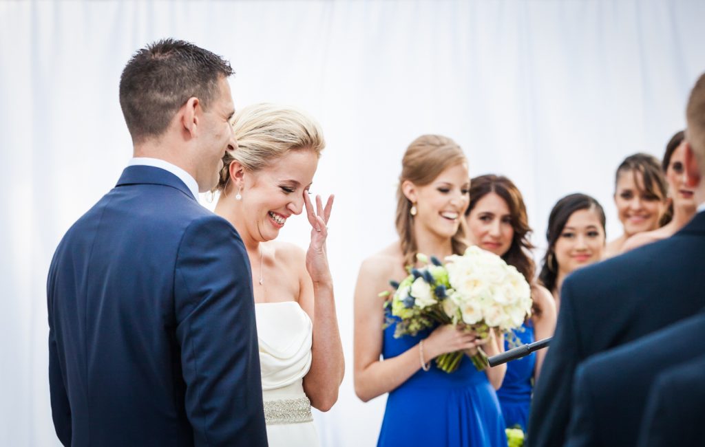 Bride wiping away tear during ceremony for an article on how to become a wedding officiant in NYC
