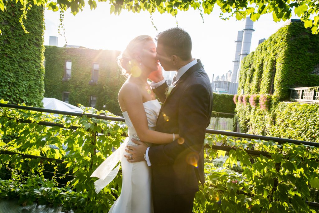 Bride and groom kissing with sun flair for an article on how to become a wedding officiant in NYC