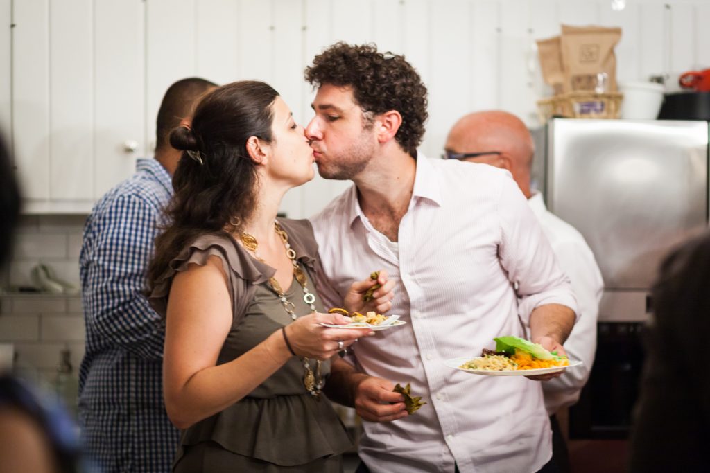 Couple holding plates and kissing
