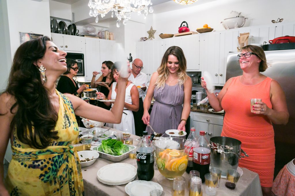 Guests enjoying a party in a Manhattan apartment kitchen