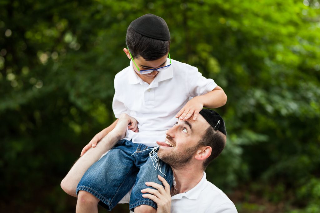 Man holding boy on his shoulder and making funny face