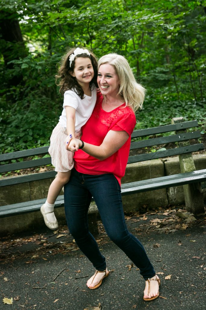 Woman in red holding little girl and dancing in Prospect Park