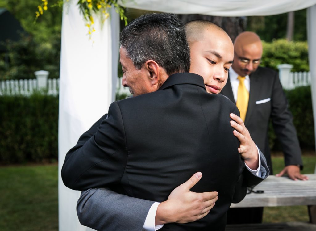 Groom hugging father of the bride at Highlands Country Club wedding ceremony