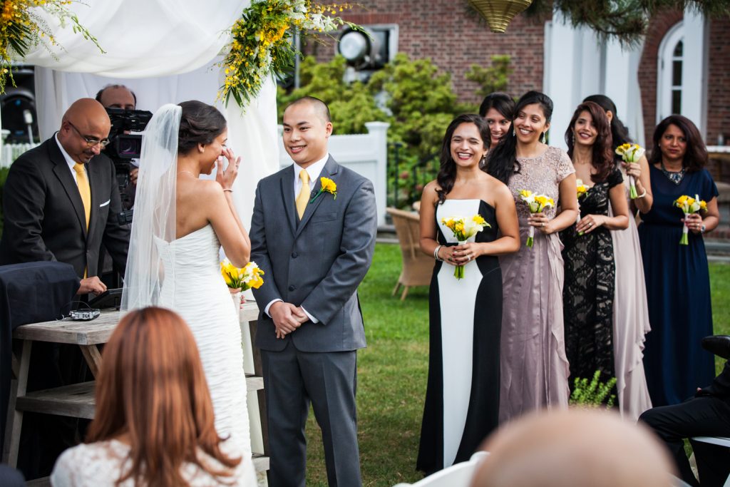 Bride wiping away tear in front of bridal party at Highlands Country Club wedding ceremony