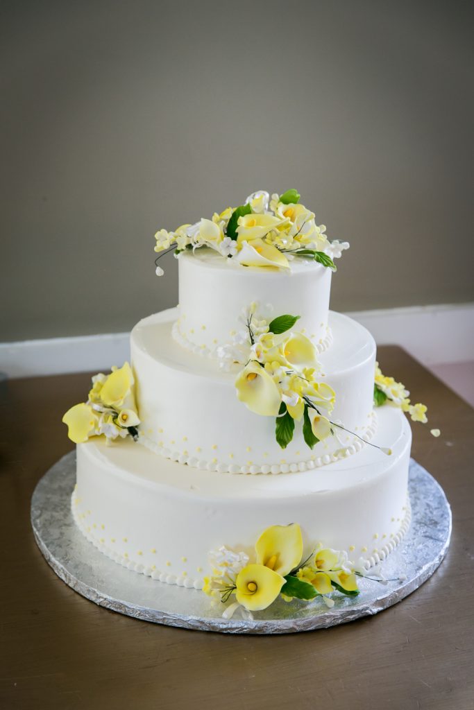 Wedding cake with yellow flowers at Highlands Country Club wedding ceremony