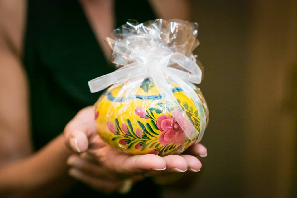 Hand holding a yellow and multicolored bomboniere guest favor