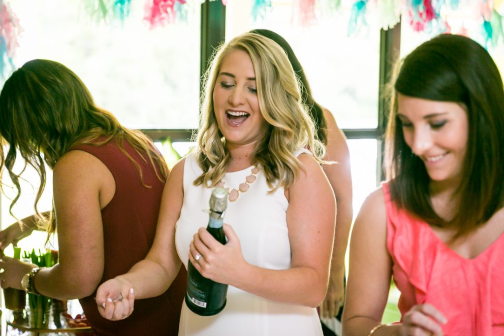 Bride-to-be opening bottle of champagne at a Florida bridal shower