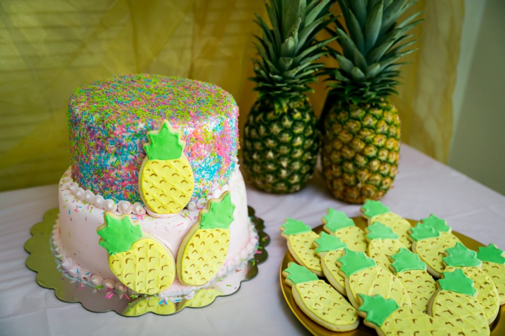 Cake decorated with pineapple cookies and two real pineapples