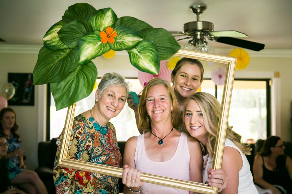 Guests looking through gold frame decorated with leaves