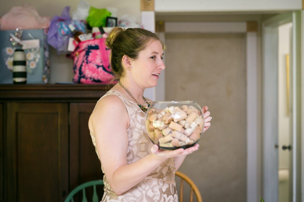 Female guest holding a fish bowl filled with wine corks