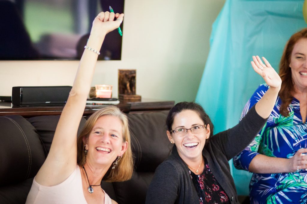 Two female guests with hands raised during Florida bridal shower