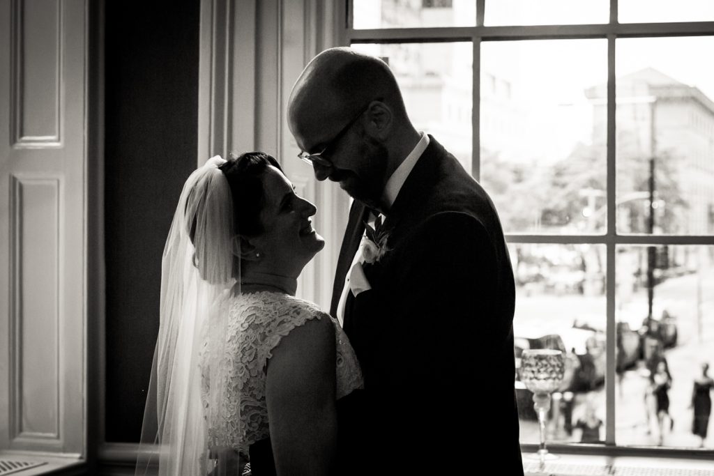 Black and white photo of backlit bride and groom