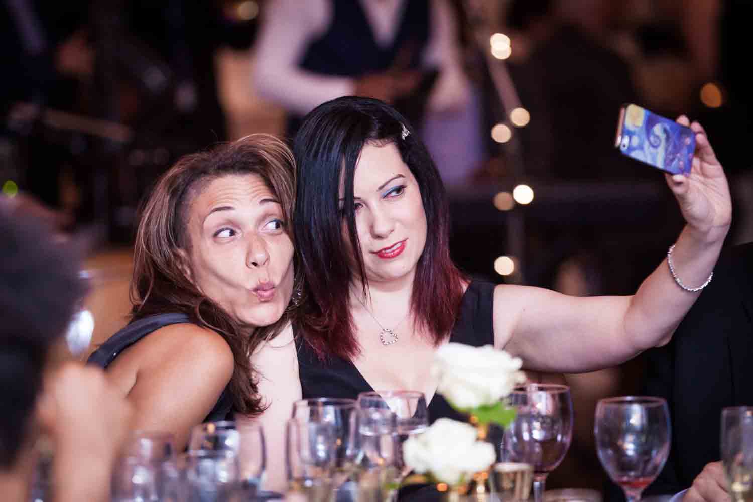 India House wedding photos of two female guests taking a selfie at a table