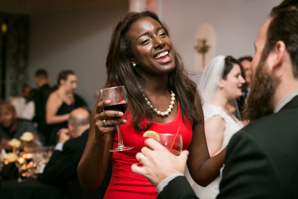 African American woman wearing red dress dancing at India House wedding