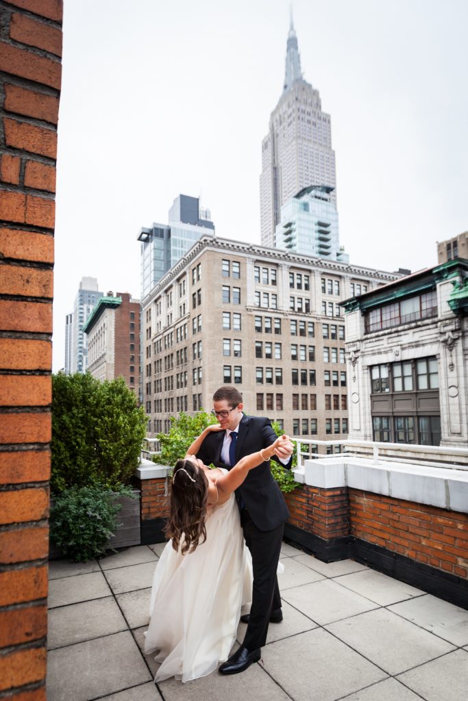 Bride and groom dancing on terrace with Empire State Building in background