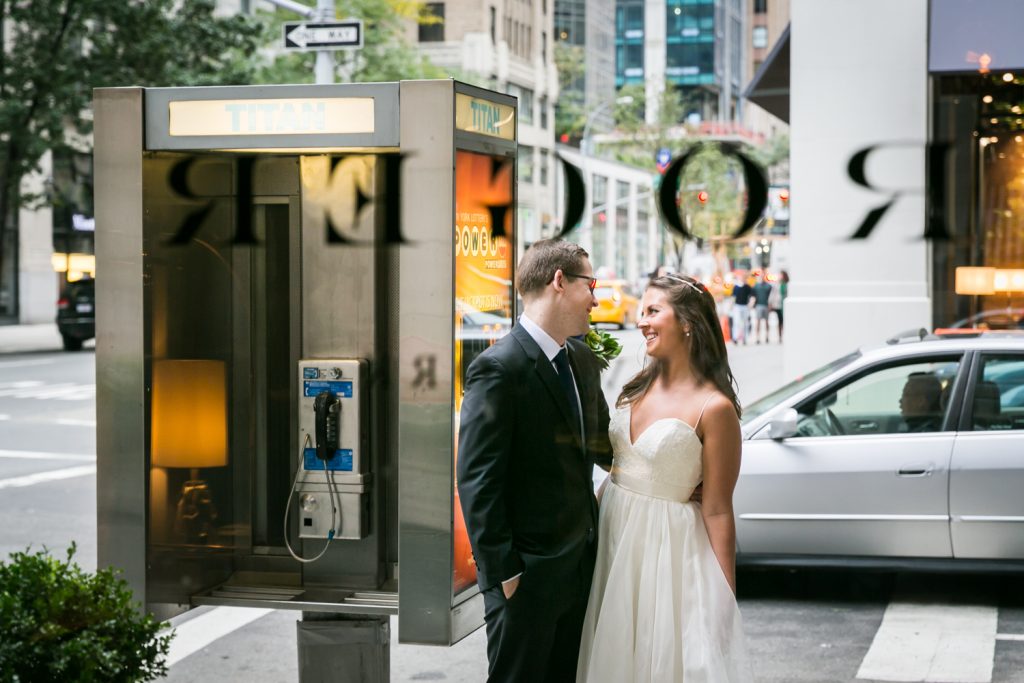 View of bride and bridegroom beside a phone booth